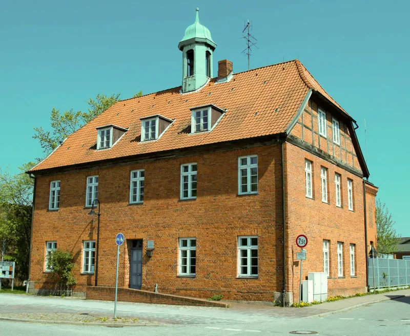 Ein roter Backsteinbau mit einem Türmchen.
