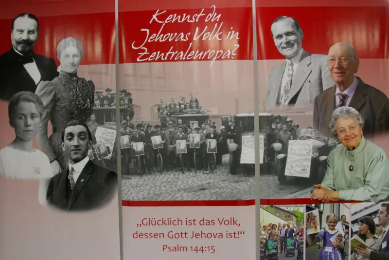 Oldtimer mit Schildern "Wir glauben an die Aufrichtung des Königreiches Gottes auf Erden eingerahmt von Zeugen Jehovas mit Schildern die die Zeitschrift "Trost" ankündigen. Darum einige Portraits verfolgter Zeugen Jehovas.