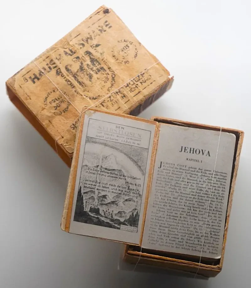 Ein auf dem Innentitel aufgeschlagenes Buch liegt im Inneren einer Streichholzschachtel.
