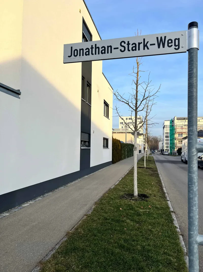 Eine Straße, das Straßenschild im Vordergrund.