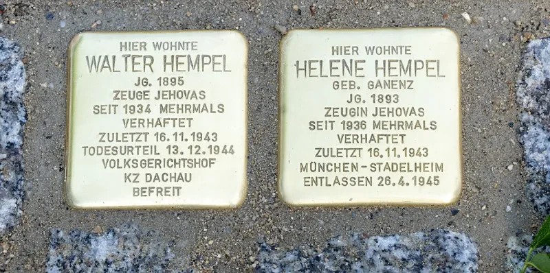 Ein Stolperstein mit der Inschrift: "Hier wohnte Walter Hempel, Jahrgang 1895, Zeuge Jehovas, seit 1934 mehrmals verhaftet, zuletzt 16.11.1943, Todesurteil 13.12.1944 Volksgerichtshof, KZ Dachau befreit". Daneben liegt der Stolperstein für seine Ehefrau mit der Inschrift: "Hier wohnte Helene Hempel, geborene Ganenz, Jahrgang 1893, Zeugin Jehovas, seit 1936 mehrmals verhaftet, zuletzt 16.11.1943, München-Stadelheim, entlassen 26.4.1945".