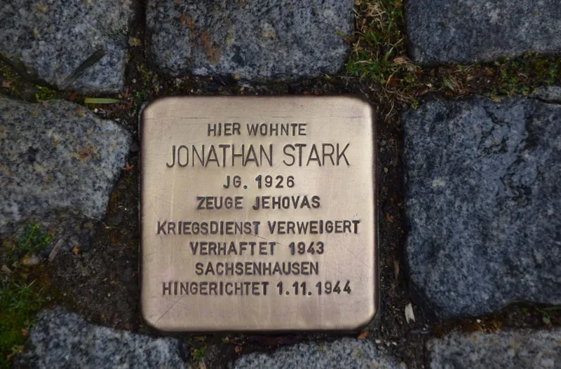 Ein Stolperstein mit der Inschrift: Hier wohnte / Jonathan Stark / Jg. 1926 / Zeuge Jehovas / Kriegsdienst verweigert / Verhaftet 1943 / Sachsenhausen / Hingerichtet 1.11.1944"
