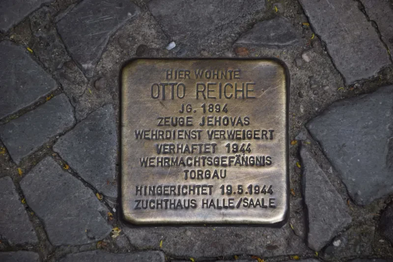 Ein Stolperstein mit der Inschrift: "Hier wohnte / Otto Reiche / Jg. 1894 / Zeuge Jehovas / Wehrdienst verweigert / Verhaftet 1944 / Wehrmachtsgefängnis Torgau / Hingerichtet 19.5.1944 / Zuchthaus Halle/Saale"