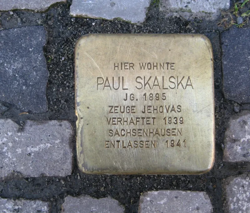 Ein Stolperstein mit der Aufschrift: Hier wohnte Paul Skalska / Jg. 1895 / Zeuge Jehovas / Verhaftet 1938 / Sachsenhausen / Entlassen 1941