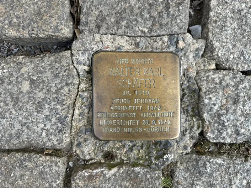 Ein Stolperstein mit der Inschrift: "Hier wohnte Walter Karl Schäfer, Jahrgang 1910, Zeuge Jehovas, verhaftet 1942, Kriegsdienst verweigert, hingerichtet 26.9.1942, Brandenburg-Görden".