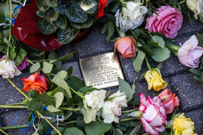 Stolperstein für Martin Weinhold in Freital-Pesterwitz, Freitaler Str. 5 b am Tag der Verlegung, mit Blumenschmuck.