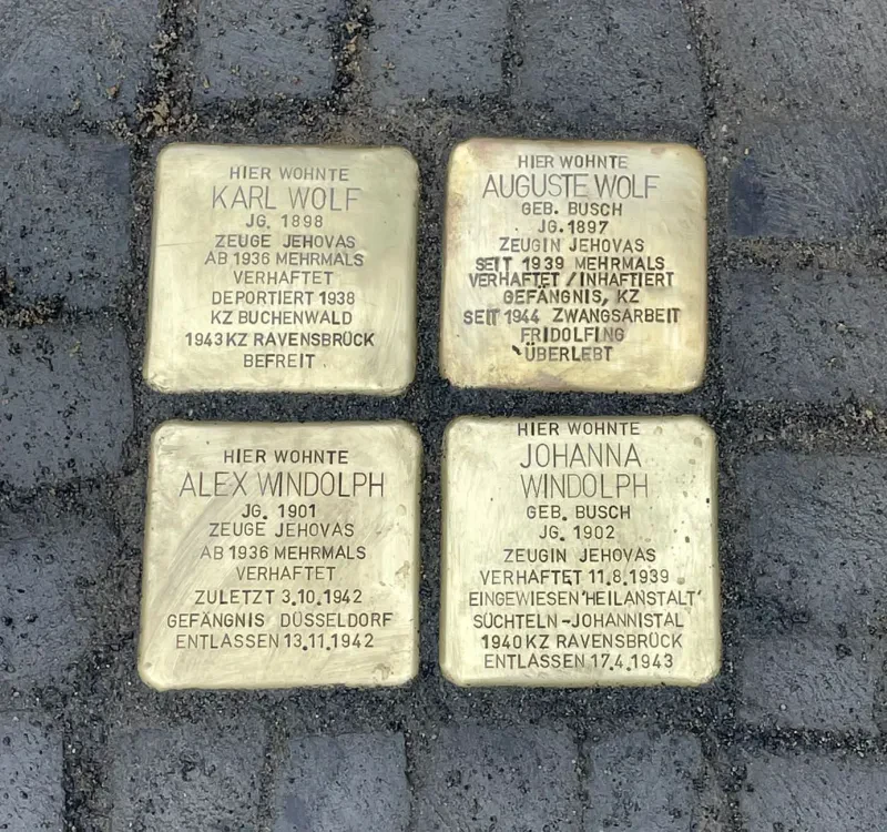 Vier Stolpersteine im Straßenpflaster.