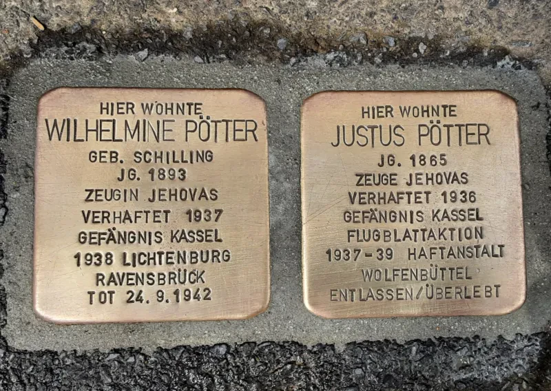Zwei Stolpersteine mit der Aufschrift: "Wilhelmine Pötter / geb. Schilling / Jg. 1893 / Zeugin Jehovas / Verhaftet 1937 / Gefängnis Kassel / 1938 Lichtenburg / Ravensbrück / Tot 24.9.1942" "Hier wohnte / Justus Pötter / Jg. 1865 / Zeuge Jehovas / Verhaftet 1936 / Gefängnis Kassel / Flugblattaktion / 1937-39 Haftanstalt Wolfenbüttel / Entlassen/Überlebt"