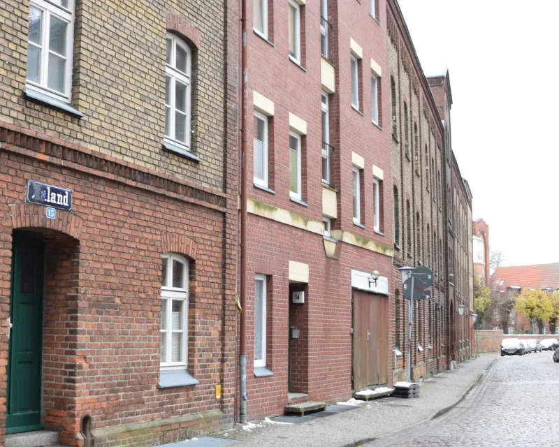 Eine Häuserzeile, im Vordergrund die Nr. 15 (Altbau) und die Nr. 14 (Neubau).