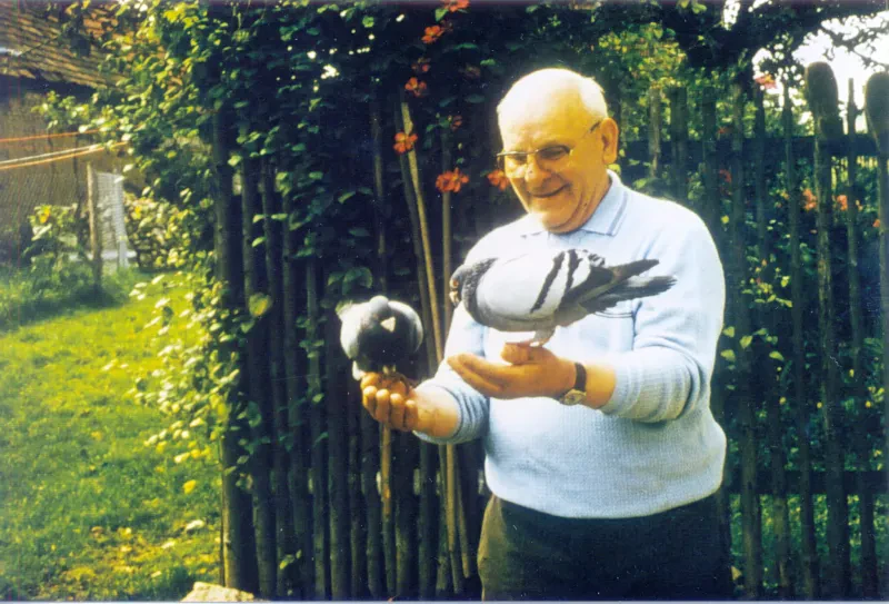 Willy Thiel bei einem Besuch in Thüringen, Ende der 1970er Jahre. er steht vor einem Gartenzaun und hält auf jeder Hand eine Taube.