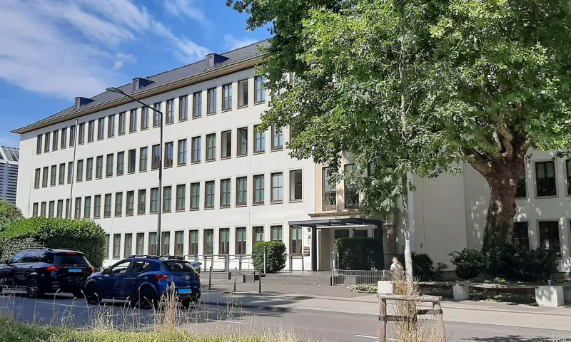 Ein langgestrecktes, vierstöchiges, weiß verputztes Gebäude mit grauem Satteldach.