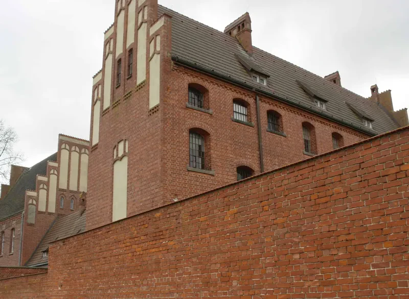 Im Vordergrund das ehemalige Ueckermünder Amtsgerichtsgefängnis mit vergitterten Fenstern, im Hintergrund das Amtsgerichtsgebäude von hinten.