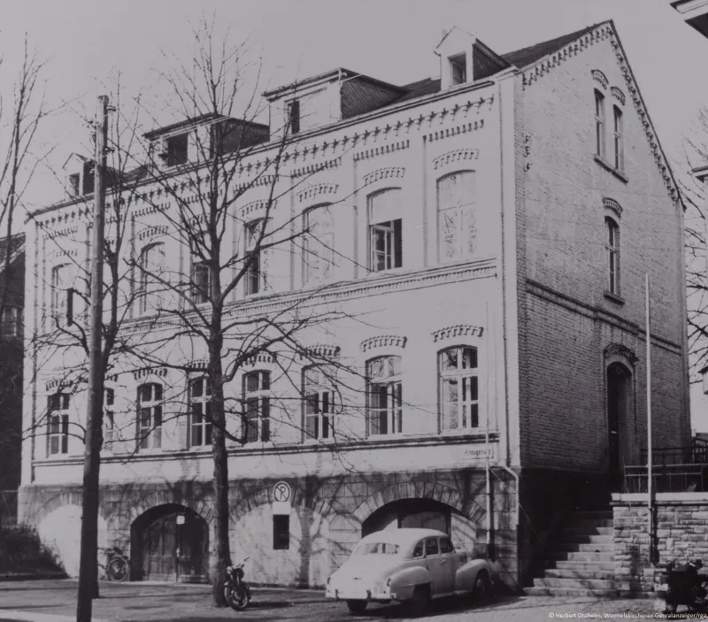 Eine Treppe führt zum Eingang an der rechten Seite eines zweistöckigen kastenförmigen Gebäudes mit Satteldach und einem kleinen Schild mit der Aufschrift "Amtsgericht". Auf der Vorderseite sind in beiden Etagen acht hohe Fenster. Das Gebäude steht auf einem Kellersockel mit zwei jeweils zweiflügeligen Toren. Vor einem Tor steht ein alter VW Käfer.