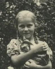 Ein Mädchen blickt in die Kamera, sie hält eine Katze in den Armen.