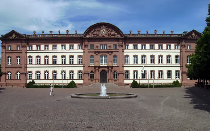 Ein Schloss, davor ein Springbrunnen.